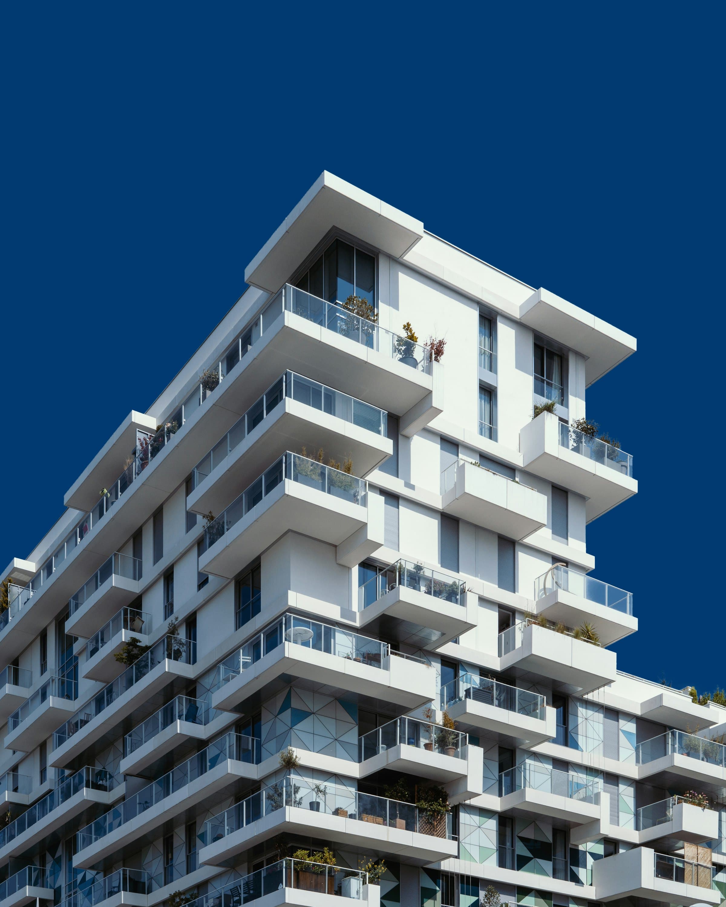 White block with cantilevered balconies against a deep blue sky