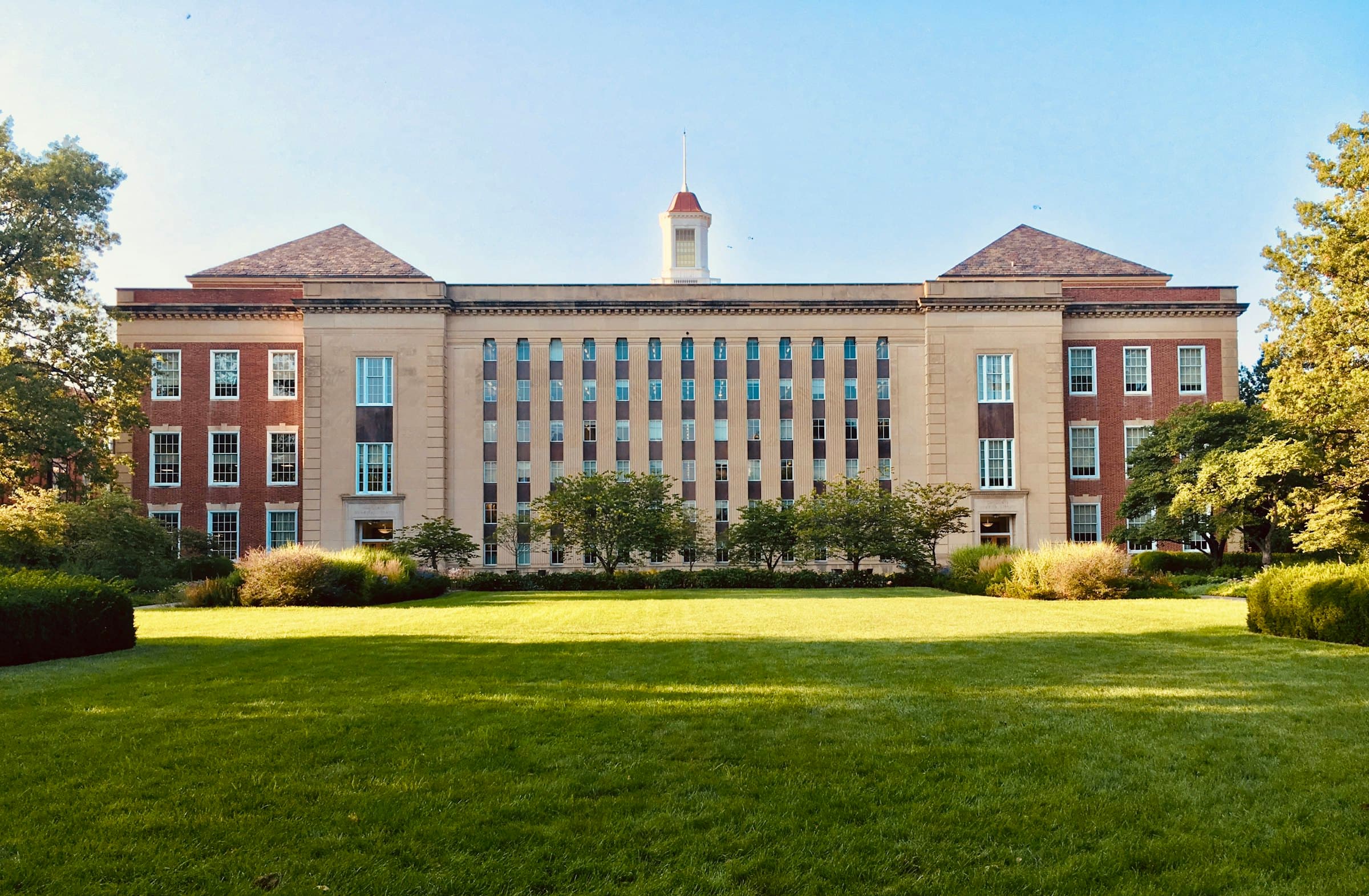 Classical institutional building seen across a lawn