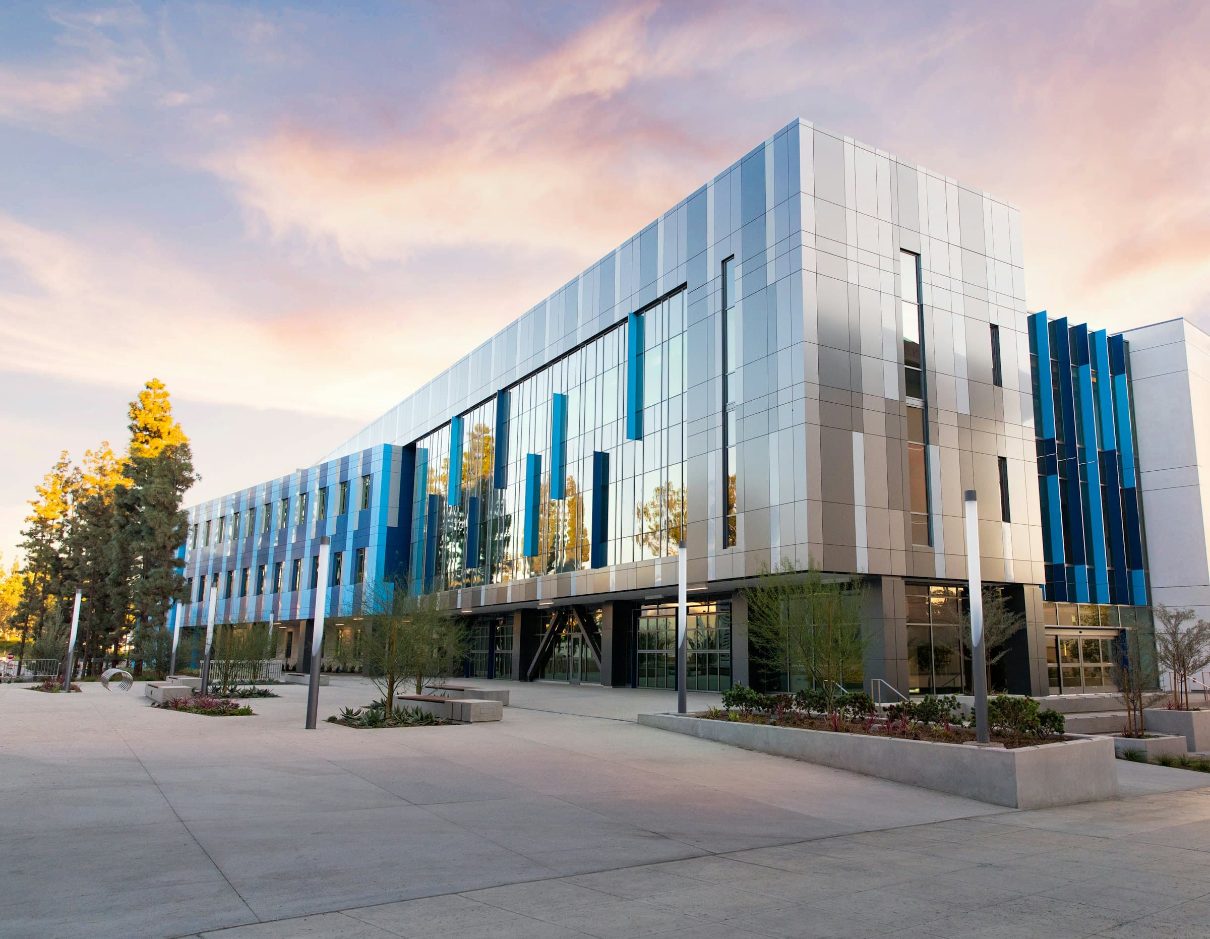 Contemporary campus building with a glazed, metal-clad facade at dusk