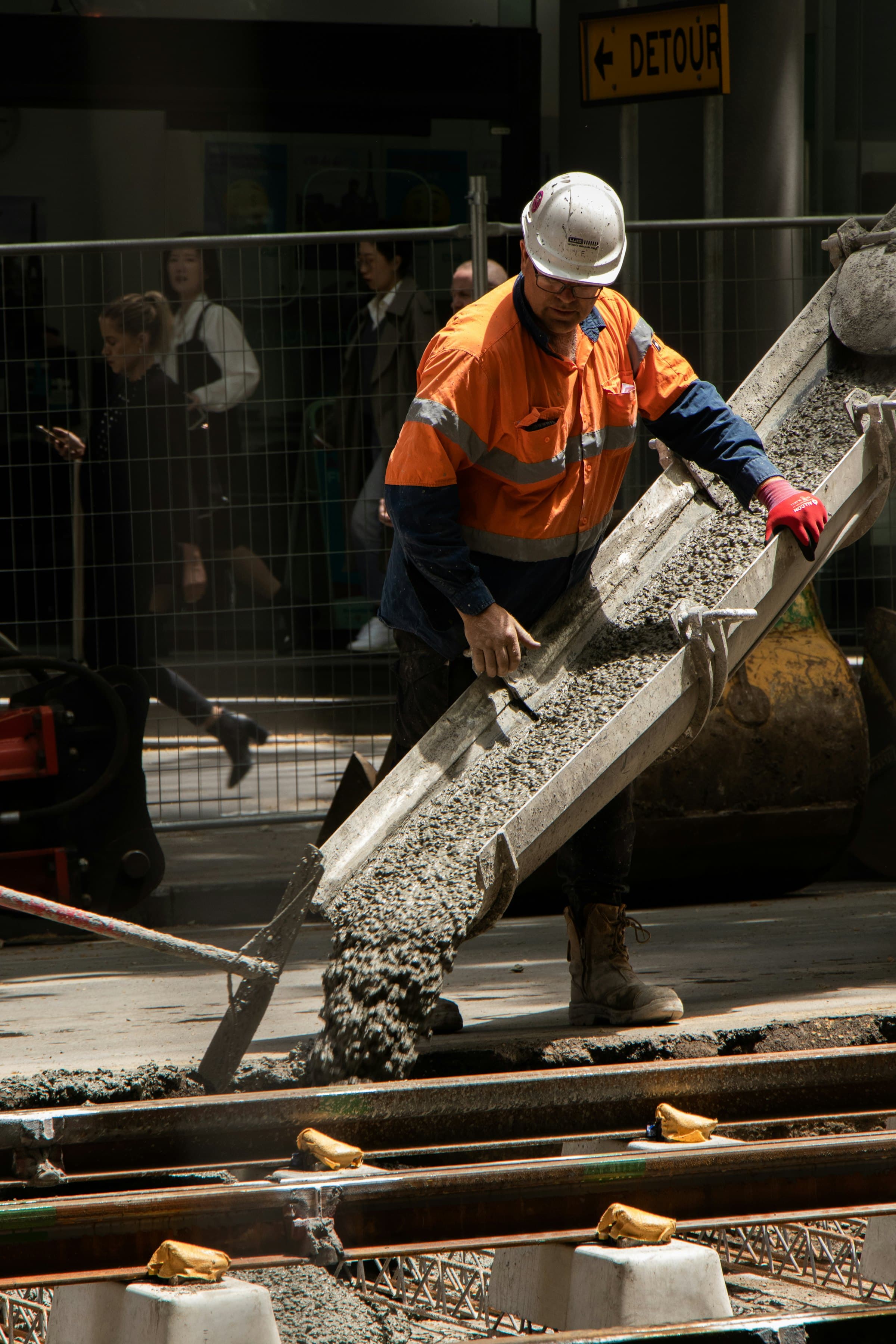 Operative in PPE guiding a concrete pour at ground level
