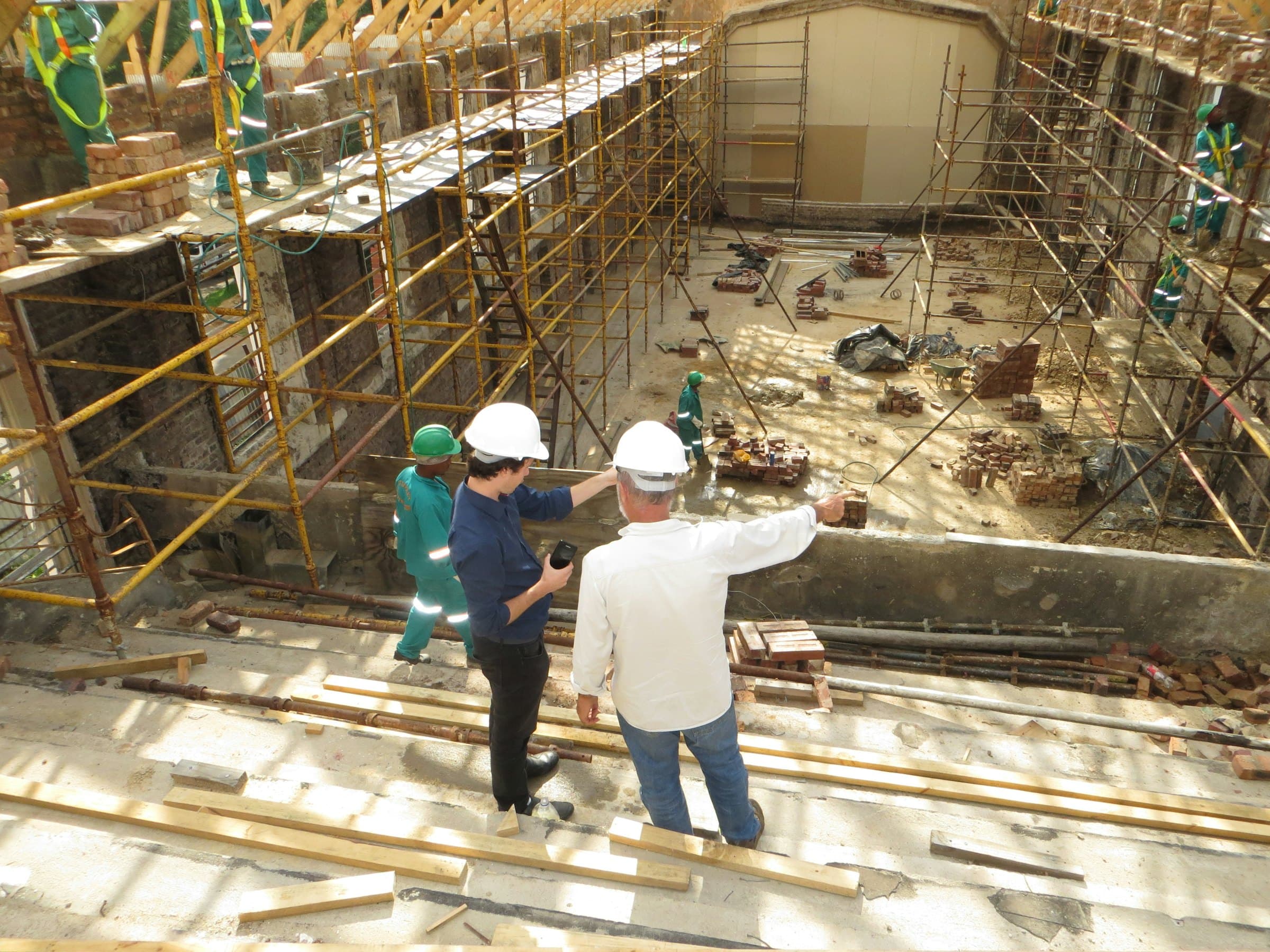Site engineers in hard hats reviewing a basement excavation