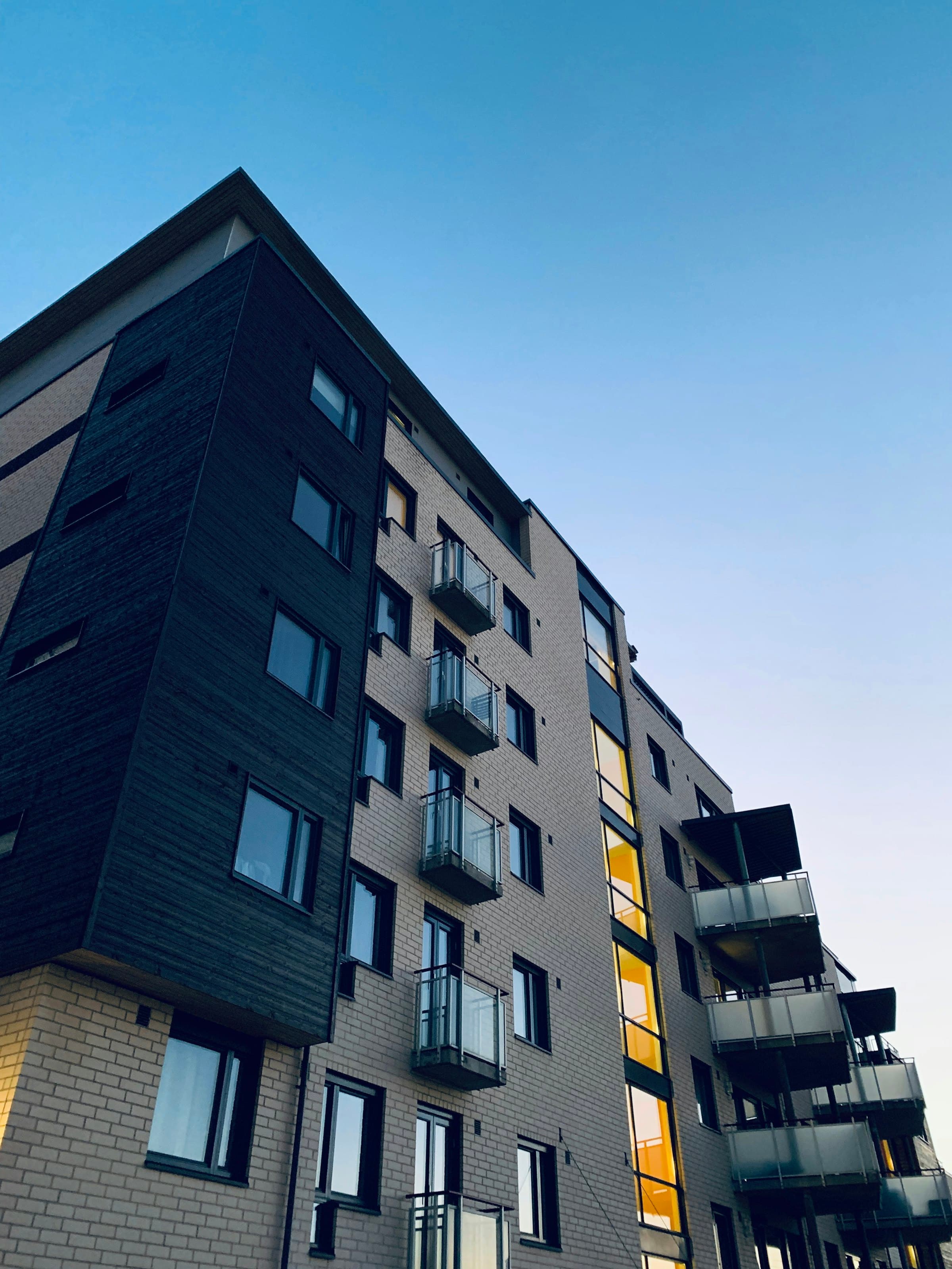 Corner of a dark-clad residential block with recessed balconies